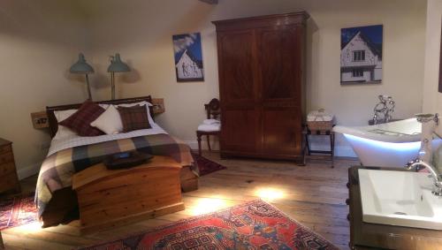 a bedroom with a bed and a tub and a sink at The Cross Keys in Saffron Walden