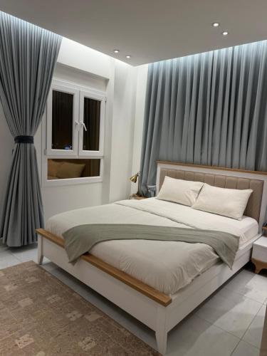 a bedroom with a large bed and a window at Abu Rakan Apartment in Muscat