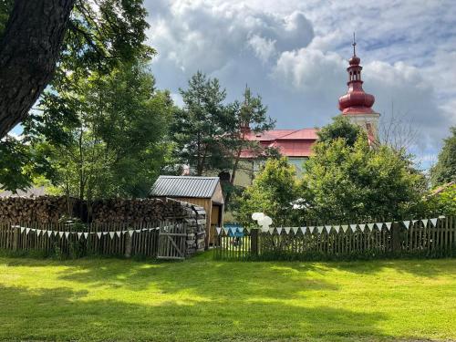 a fence in a yard with a building in the background at Apartmán Ekonomy 