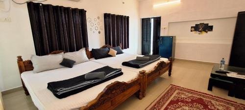 a bedroom with two beds with black and white pillows at SALT beach resort classic in Kālapettai