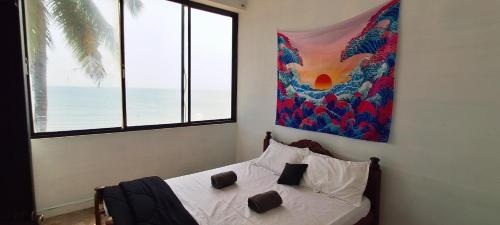 a bedroom with a bed with a painting on the wall at SALT beach resort classic in Kālapettai