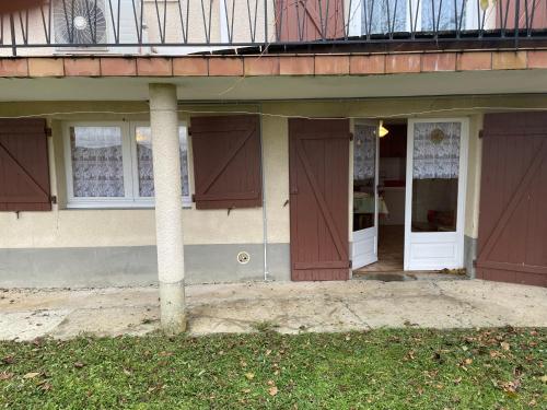 a building with brown doors and a balcony at Vue SUR VIADUC DE MILLAU in Millau