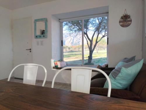 a living room with a couch and a table and a window at Atardeceres del dique in Cortaderas