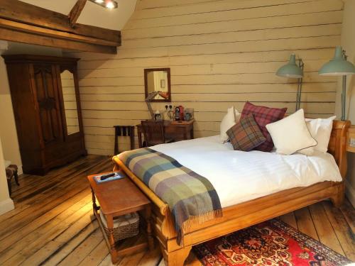 a bedroom with a bed in a room with wooden floors at The Cross Keys in Saffron Walden