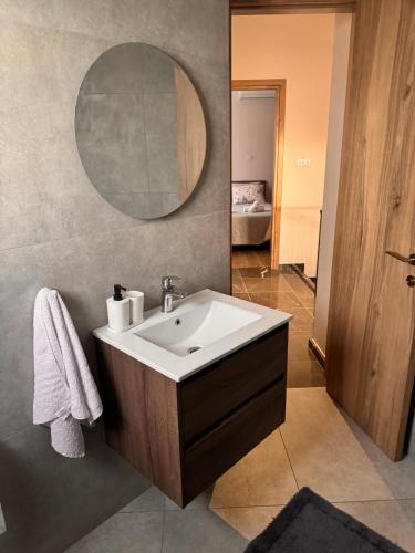 a bathroom with a sink and a mirror at Maroulla's Modern & Spacious Family Home near the Beach in Limassol