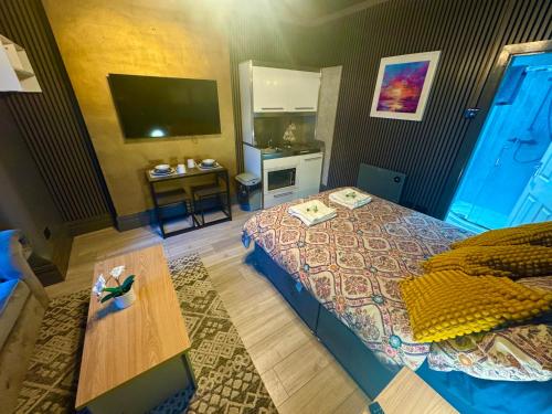 a bedroom with a bed and a table and a television at Reads Avenue - Luxury Ground Floor Studio - Next Door to H&A Social Club in Blackpool