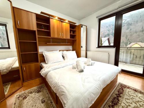 a bedroom with a large bed and a large window at Adela Mountain View Sinaia in Sinaia
