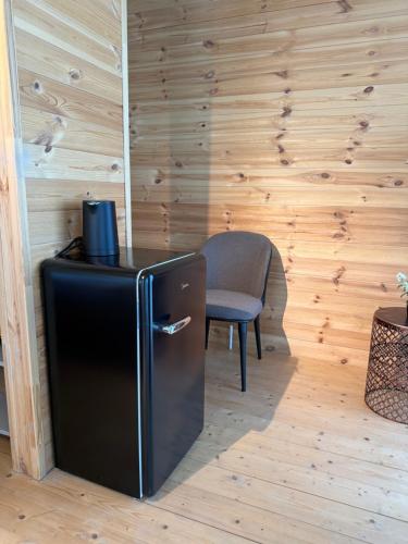 una nevera negra en una habitación con silla en Kvirike Hills Hotel, en Kobuleti