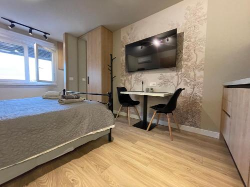 a bedroom with a bed and a table with chairs at Piazza Downtown Cozy Studio in Tirana