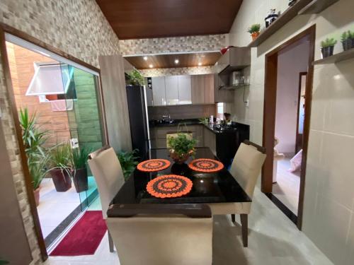 una cucina e una sala da pranzo con tavolo e sedie di Casa Bello encanto a Cachoeira Paulista