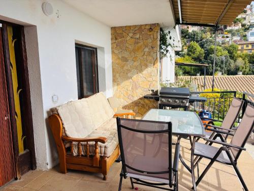 a patio with a couch and a table and a grill at House with ocean and mountain views in Santa Susanna
