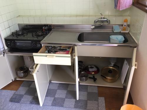 a small kitchen with a sink and a stove at Furano Rental House in Furano