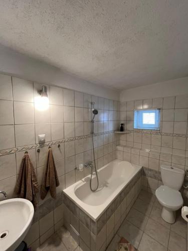 a bathroom with a tub and a toilet and a sink at Apartmán u Peťa in Babín