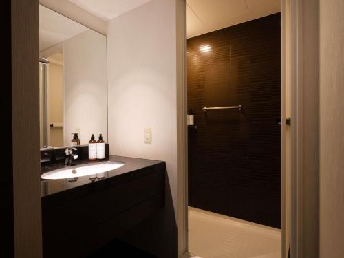 Un baño con lavabo y un espejo grande. en Mercure Kyoto Miyazu Resort & Spa, en Miyazu