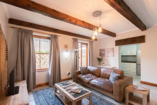 a living room with a leather couch and a table at Mountain and Tides in Kleinmond