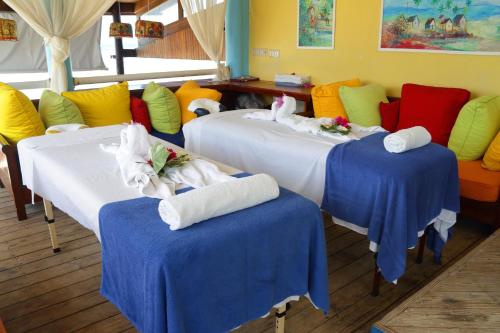 ein Zimmer mit 3 Betten und Handtüchern darauf in der Unterkunft Negril Palms in Negril