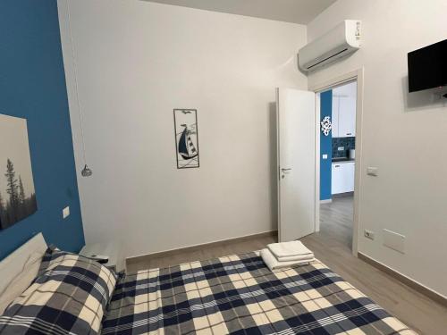 a bedroom with two beds and a tv on the wall at Alloggio Turistico Mare Blu Gaeta in Gaeta