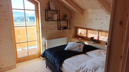 Domki pod łanem في تيلسز: غرفة نوم بها سرير في غرفة بجدران خشبية