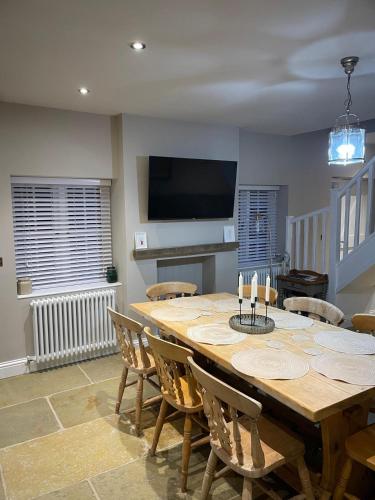 a dining room with a large wooden table and chairs at The Merchants Barn - A New Unique Town Centre Home in King's Lynn