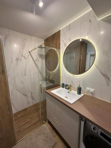 een badkamer met een wastafel en een spiegel bij Panorama 79 in Nowy Targ