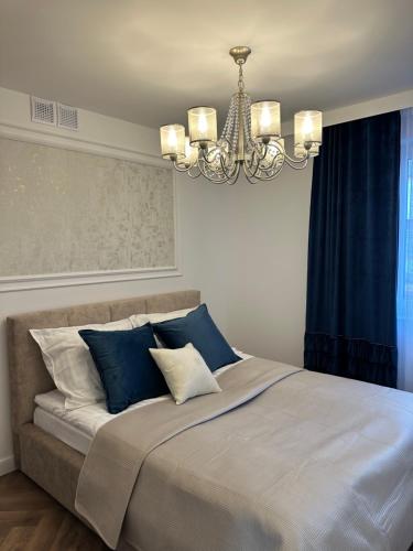 een slaapkamer met een groot bed met blauwe en witte kussens bij Panorama 79 in Nowy Targ