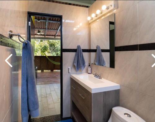 een badkamer met een wastafel, een toilet en een spiegel bij Casas Héctor Rios in Yelapa