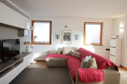 a living room with a couch and a tv at CASA BEBA - Cavalese Olimpiadi 2026 Dolomiti Affitti in Cavalese