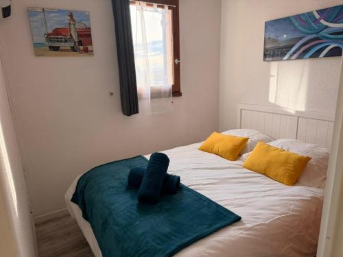 un letto con un asciugamano blu sopra di Le Barcarelle a Le Barcarès