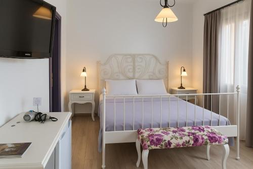 Un dormitorio con una cama, un televisor y una mesa. en Noonbir Alaçatı otel, en Cesme