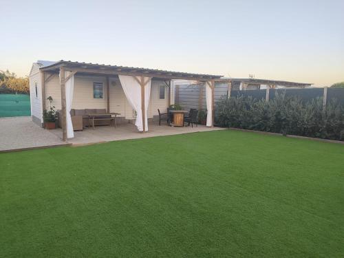 a backyard with a pergola and a green lawn at Casa Olas y Arena el Palmar in El Palmar