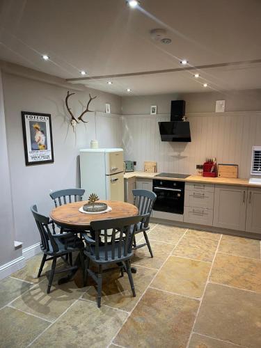 a kitchen with a table and chairs and a refrigerator at Bishops Keep - A New Unique Town Centre Home in King's Lynn