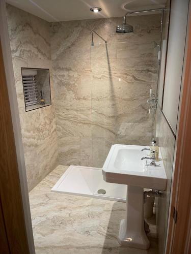 a bathroom with a sink and a shower at Bishops Keep - A New Unique Town Centre Home in King's Lynn