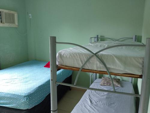 Casa na Prainha de Mambucaba في باراتي: سريرين بطابقين في غرفة صغيرة مع سرير