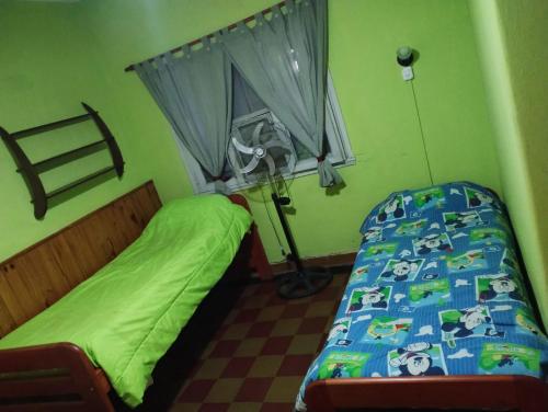 a small bedroom with a bed and a window at Depto San Clemente del tuyu centro in San Clemente del Tuyú