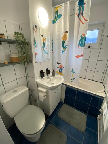 a bathroom with a toilet and a sink and a shower curtain at Straja Nest in Lupeni