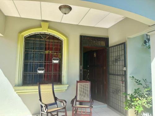 Habitación León Queen Deluxe في ليون: كرسيين جالسين على شرفة المنزل