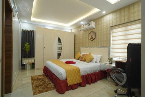 a bedroom with a bed and a desk and a television at Changanassery in Changanācheri