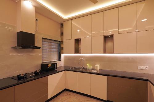 a large kitchen with white cabinets and a sink at Changanassery in Changanācheri