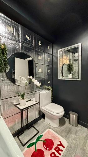 a bathroom with a toilet and a sink and a mirror at Designer Fantasy Den Boutique Seafront in Brighton & Hove
