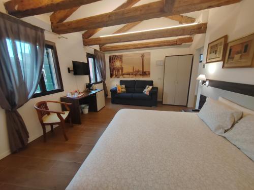 a bedroom with a bed and a couch in a room at Casa sulla Laguna CASTELLO in Venice