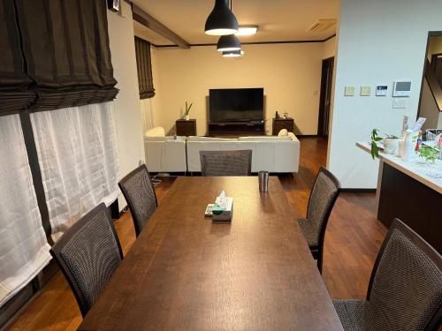 今治市にあるNine Kings Houseのテーブルと椅子とテレビのある会議室