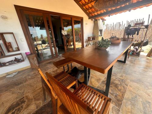 a wooden table and chairs in a room at Refúgio prea in Cruz