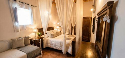 a bedroom with a bed and a couch and a window at Villa Can Mestreso Suite Ibiza in Sant Joan de Labritja