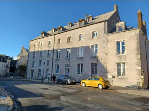 two cars parked in front of a large building at Superbe 2 pièces refait à neuf idéalement situé in Meung-sur-Loire
