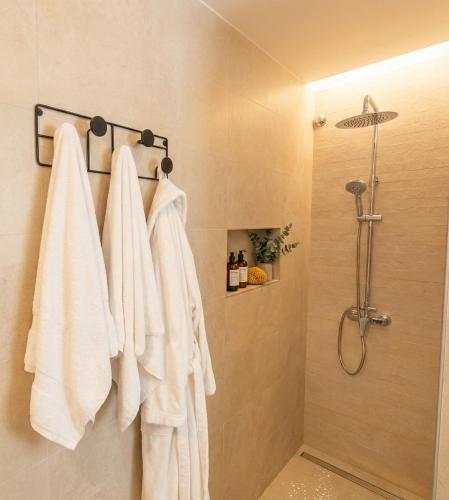 a bathroom with white towels and a shower at Villa Can Mestreso Suite Ibiza in Sant Joan de Labritja