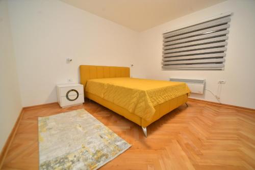 a bedroom with a yellow bed and a wooden floor at Vila Lepa in Užice