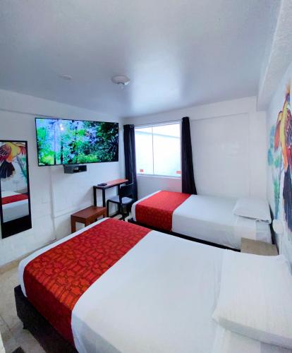 una camera d'albergo con due letti e una TV a schermo piatto di Magdalen House a Lima