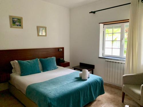 a bedroom with a large bed and a window at Hotel Louro in Óbidos