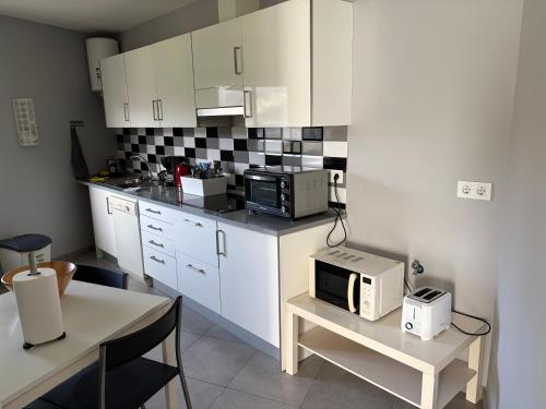 a kitchen with white cabinets and a microwave on a table at Casa Nueva in Las Palmas de Gran Canaria