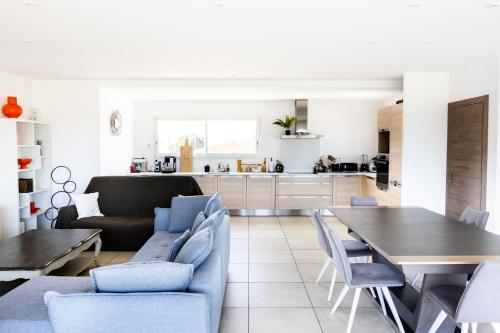 un soggiorno e una cucina con tavolo e sedie di villa boileau a Sérignan